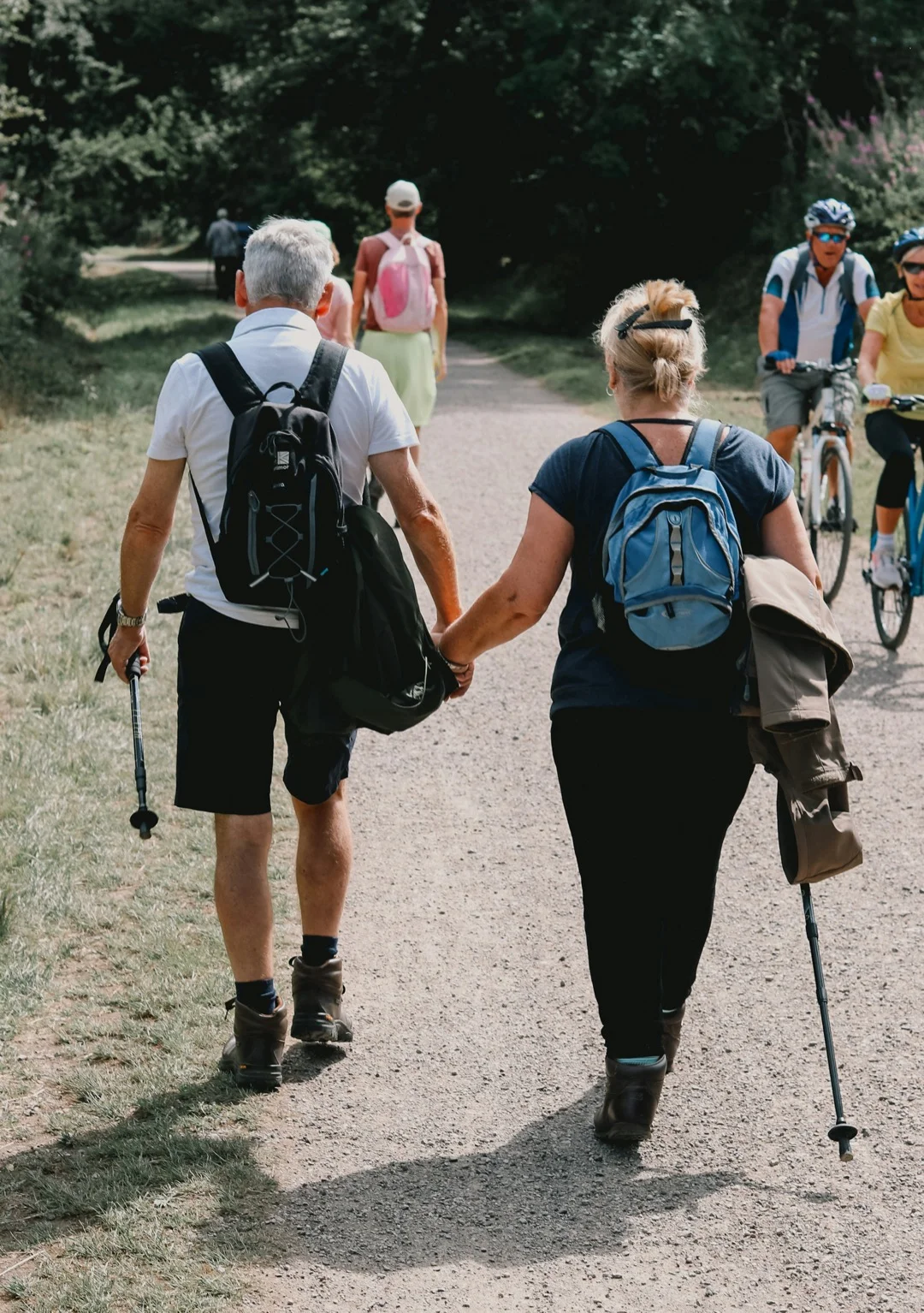 A couple hiking together on a sunny trail, staying active outdoors
